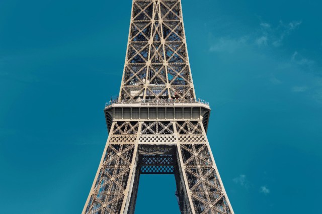 Zoomed in shot of the Eiffel Tower with blue sky in the background