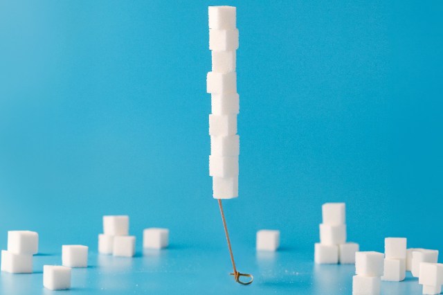 Cubes of sugar stacked up on a blue background