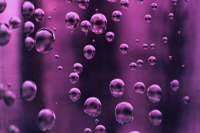 A close up of purple bubbles in a liquid