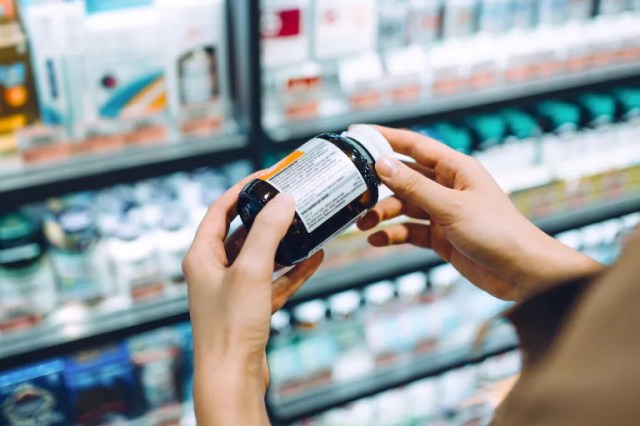 Woman holding bottle of magnesium supplements