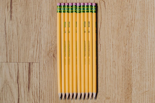 Yellow pencils lined up on a wooden desk