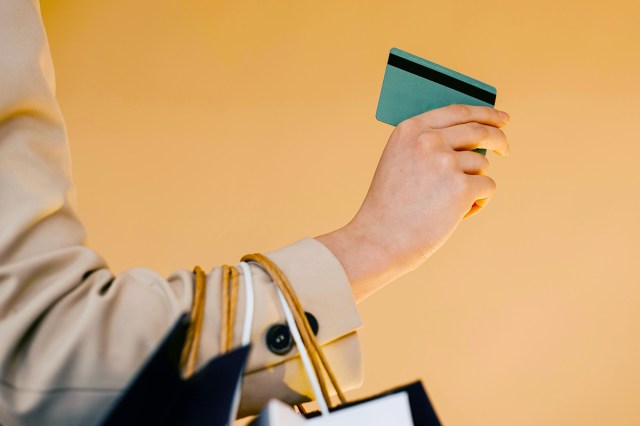 Woman holding a credit card with shopping bags in arm