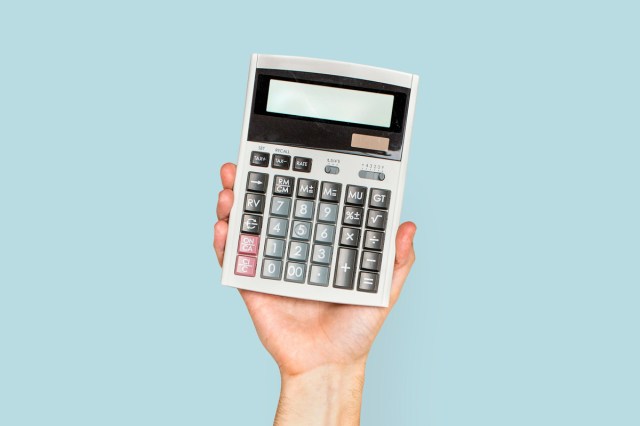 A persons hand holding a calculator