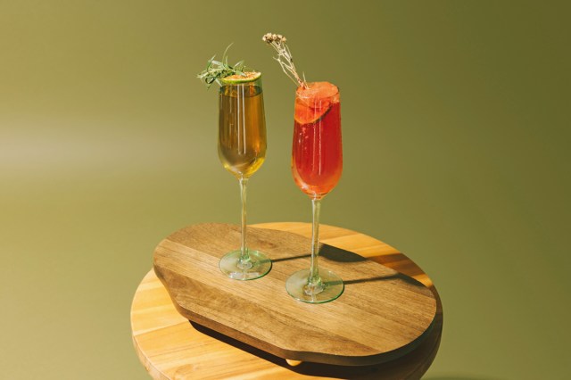 Two cocktails in skinny glasses on a green background