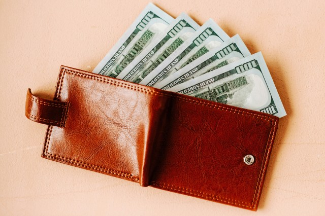 A leather wallet with hundred dollar bills