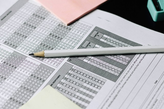 A white pencil on a table with a test 